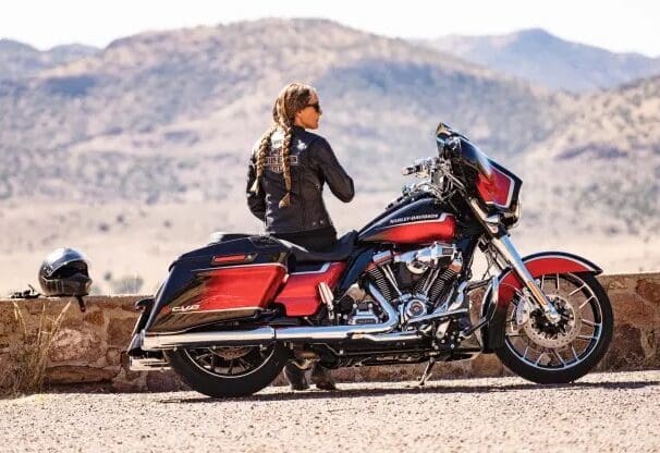 A woman in the desert next to a motorcycle. Photo sourced from CNBC.