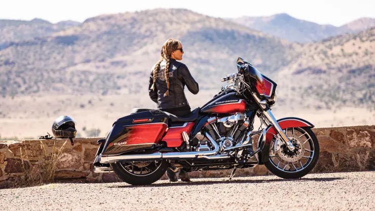 A woman in the desert next to a motorcycle. Photo sourced from CNBC.