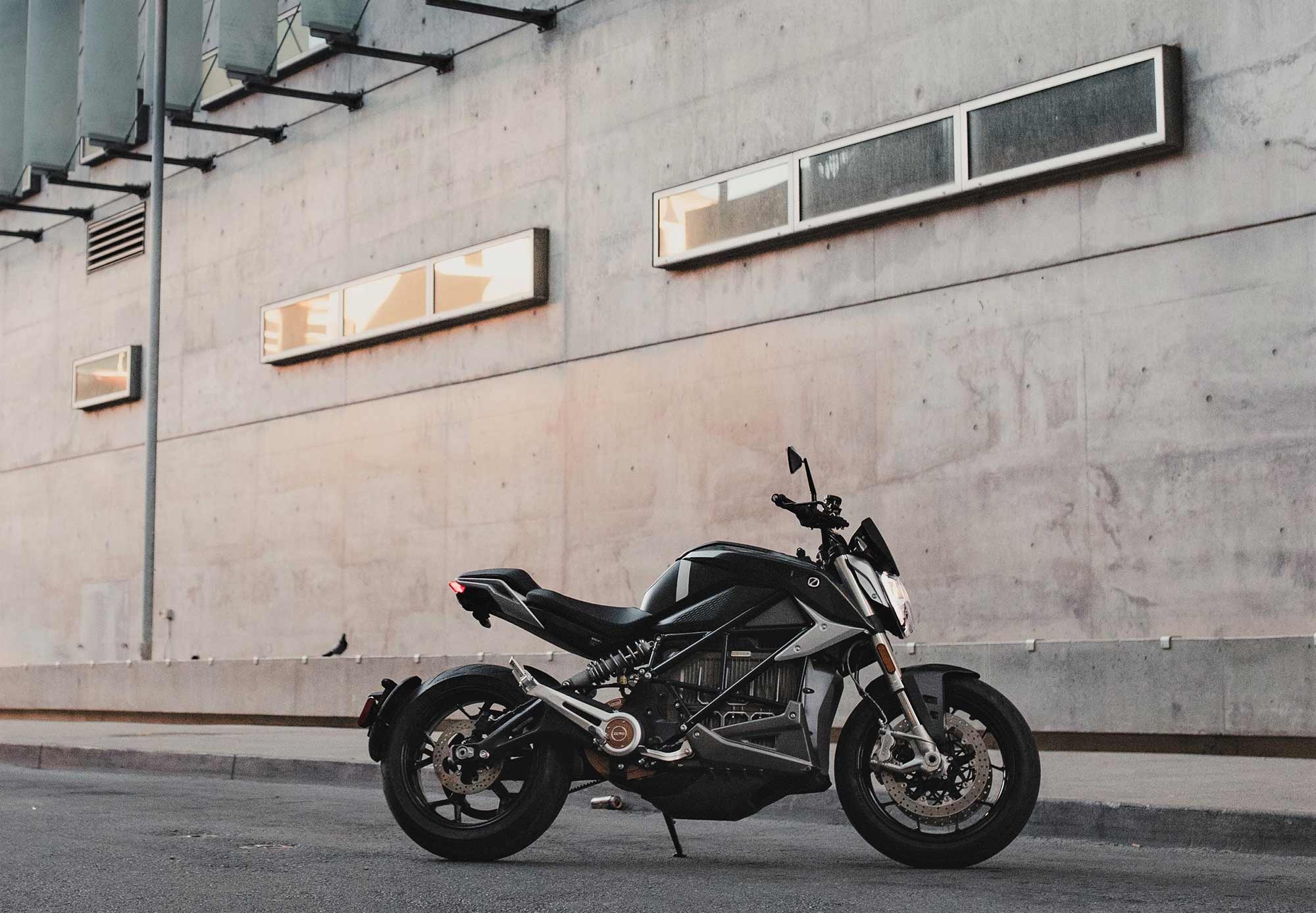 A side view of a 2022 Zero motorcycle against a brick wall.