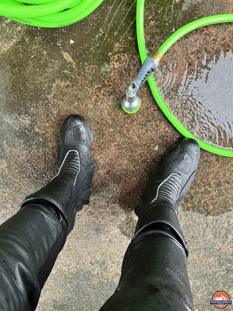 Wet Kronox Lanin Boots with leather pants tucked into ankles after being tested with garden sprayer