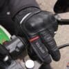 Left Richa Atlantic GTX glove holding motorcycle handlebar