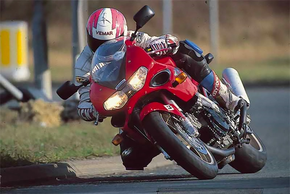 an action shot of a 1997 Suzuki 1997 TL1000S motorcycle in red
