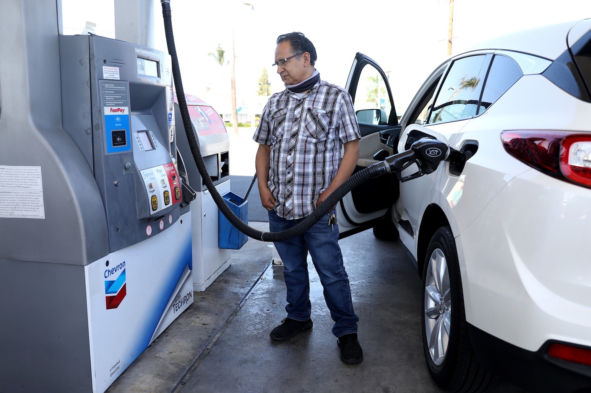 A car owner filling up his car at the gas pump.