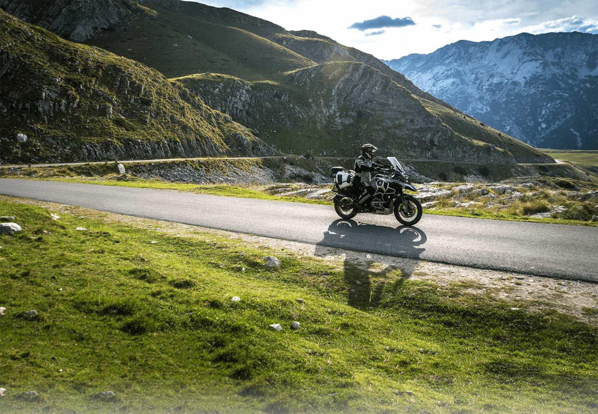 A motorcyclist enjoying a ride in green, hilly topography. Media sourced from Alchemist Adventures.