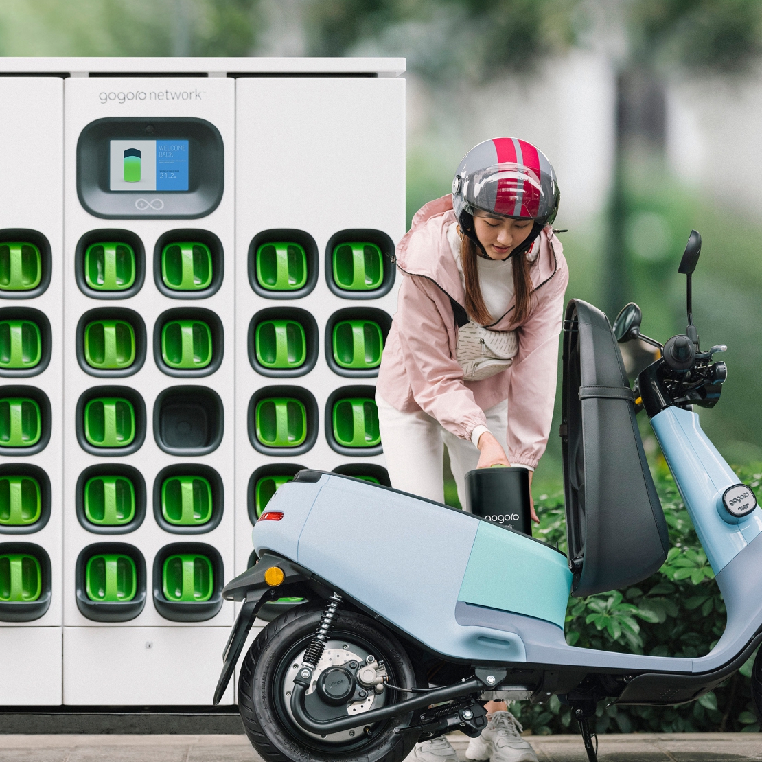 A promotional picture showing a Gogoro battery rack with the NFC tap screen at the top of the rack for paying for the battery exchange