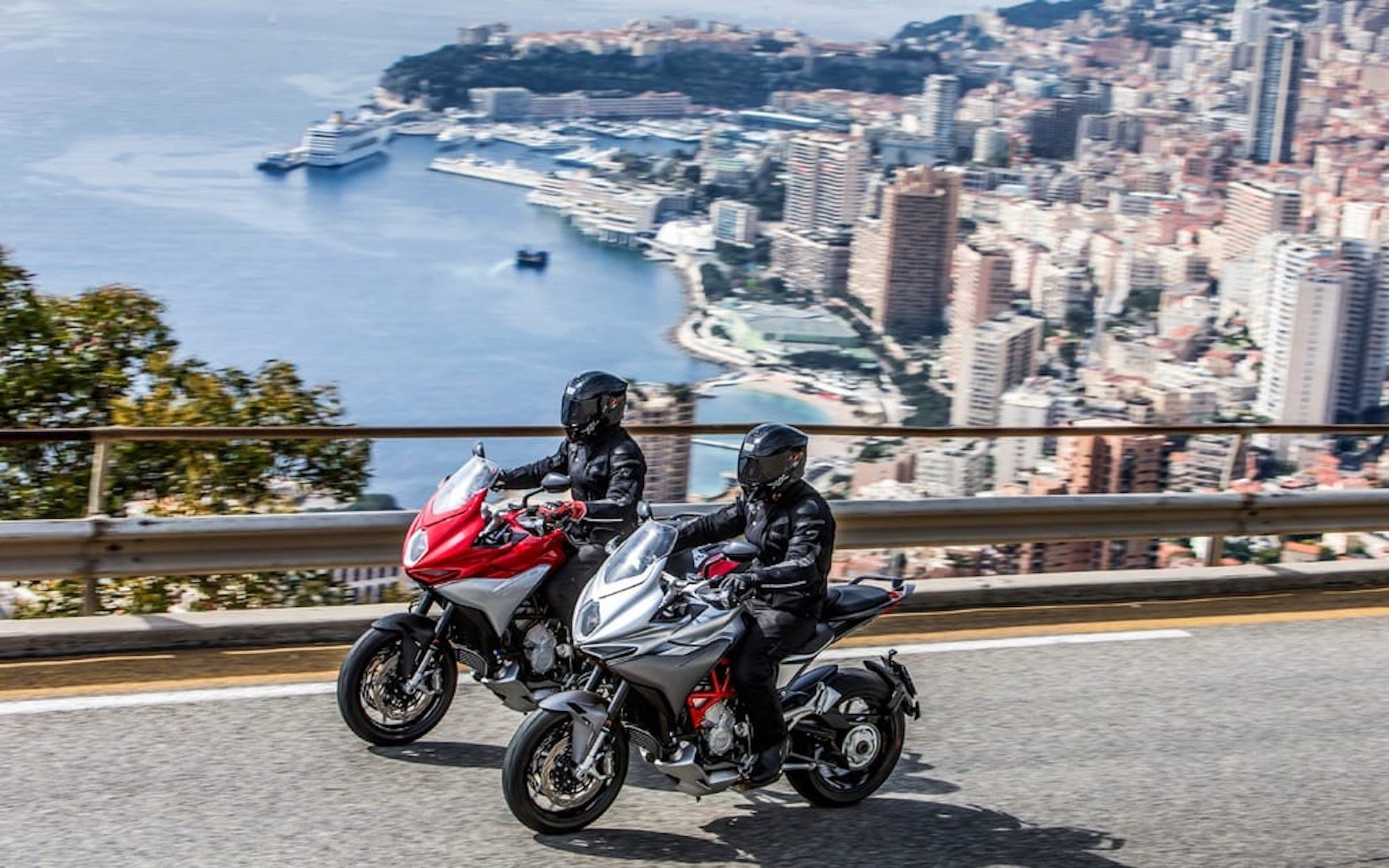 A view of two motorcyclists enjoying a sunny scoot in an urban setting