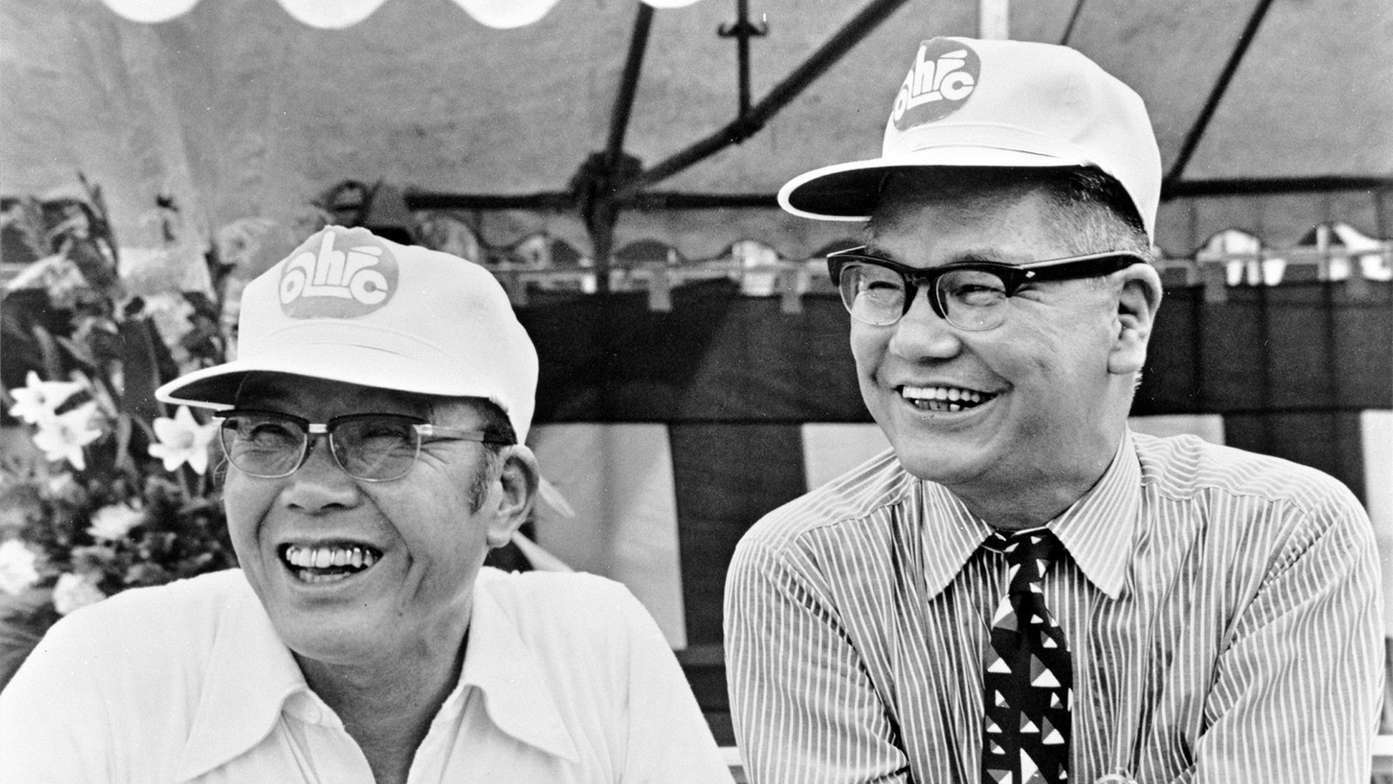 Honda Soichiro (left) and Fujisawa Takeo (right) wearing promotional caps for the Super Cub.