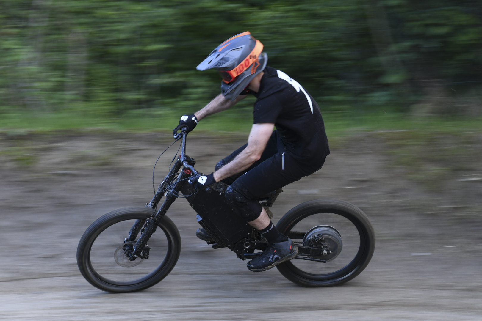 Helmeted rider descends off-road trail at speed on Stealth B-52 Bomber eBike