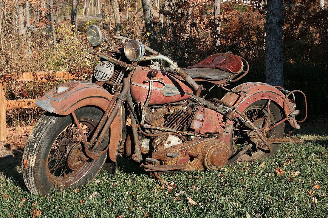 an old Harley-Davidson motorcycle sitting outside waiting to be fixed up