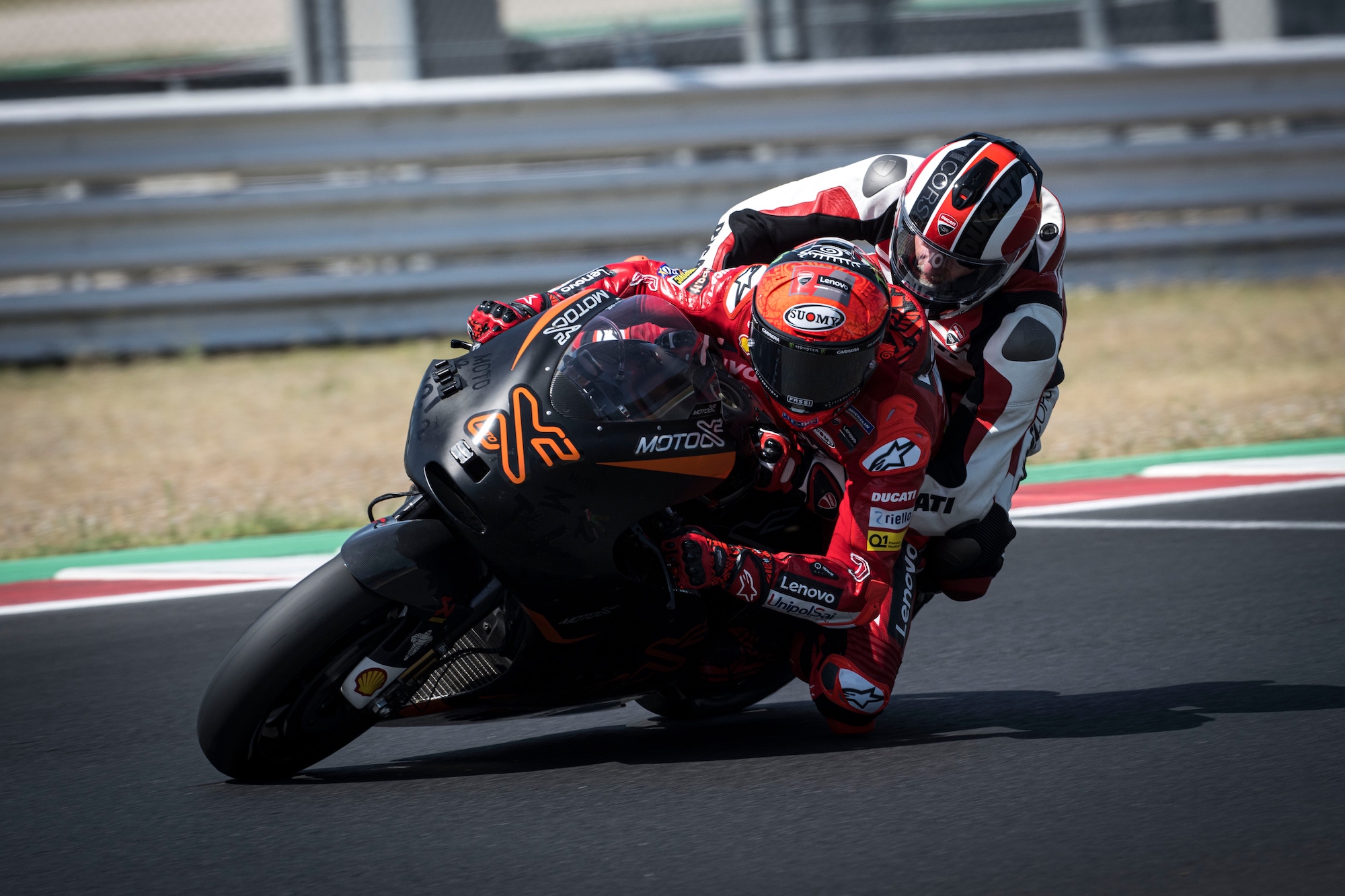 A rider getting prime instruction from a professional Ducati racer at 2022's World Ducati Week.