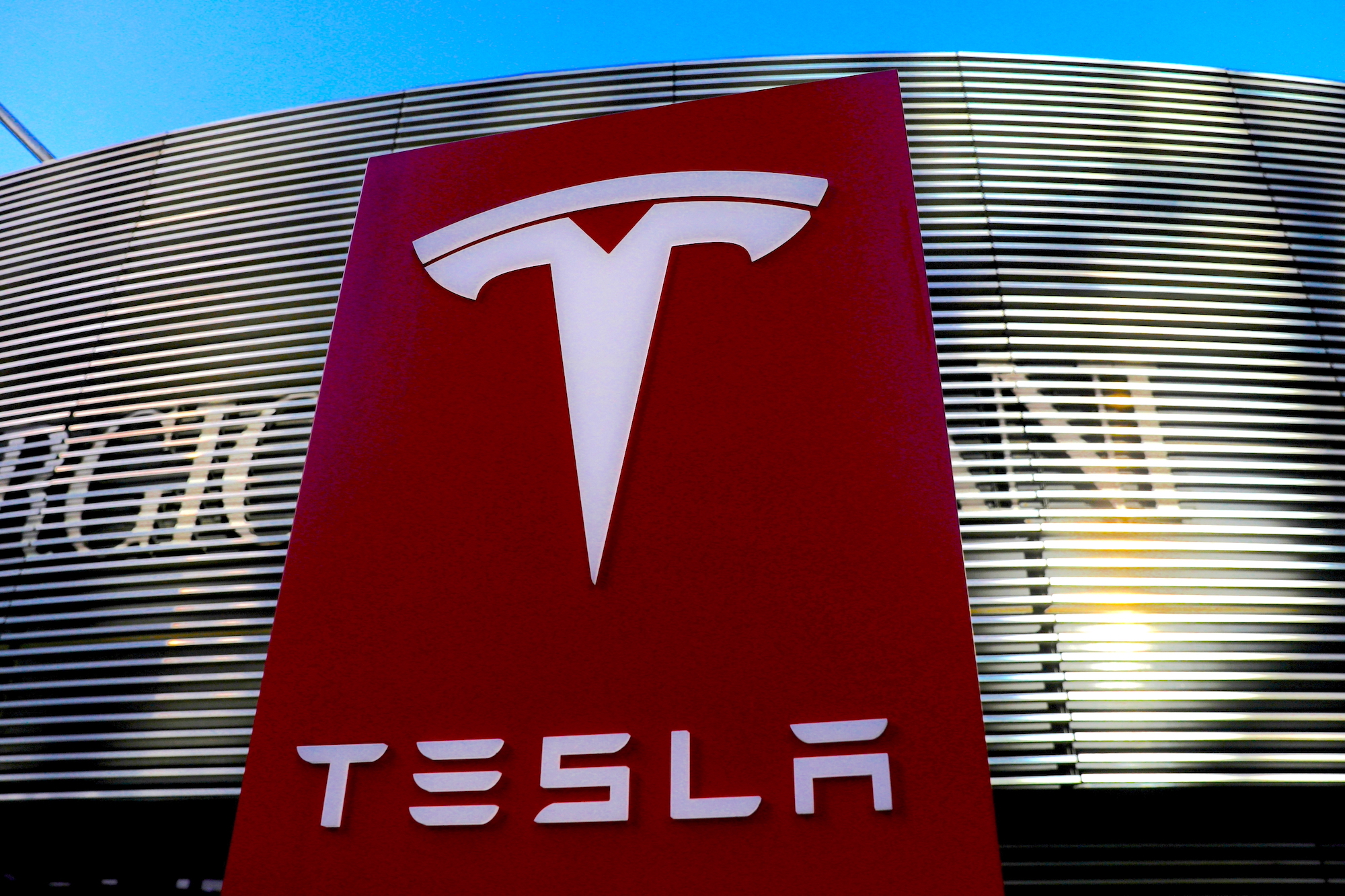 A large Tesla logo on a building dedicated to the same company. Media sourced from Auto News.