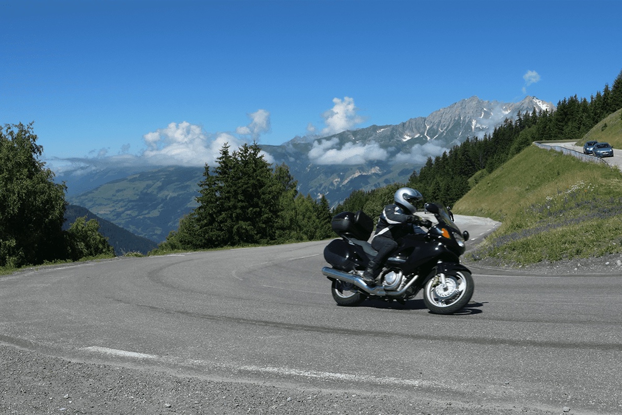 A view of a motorcyclist enjoying a winding road on a sunny day. Media sourced from Biker Girl Life.