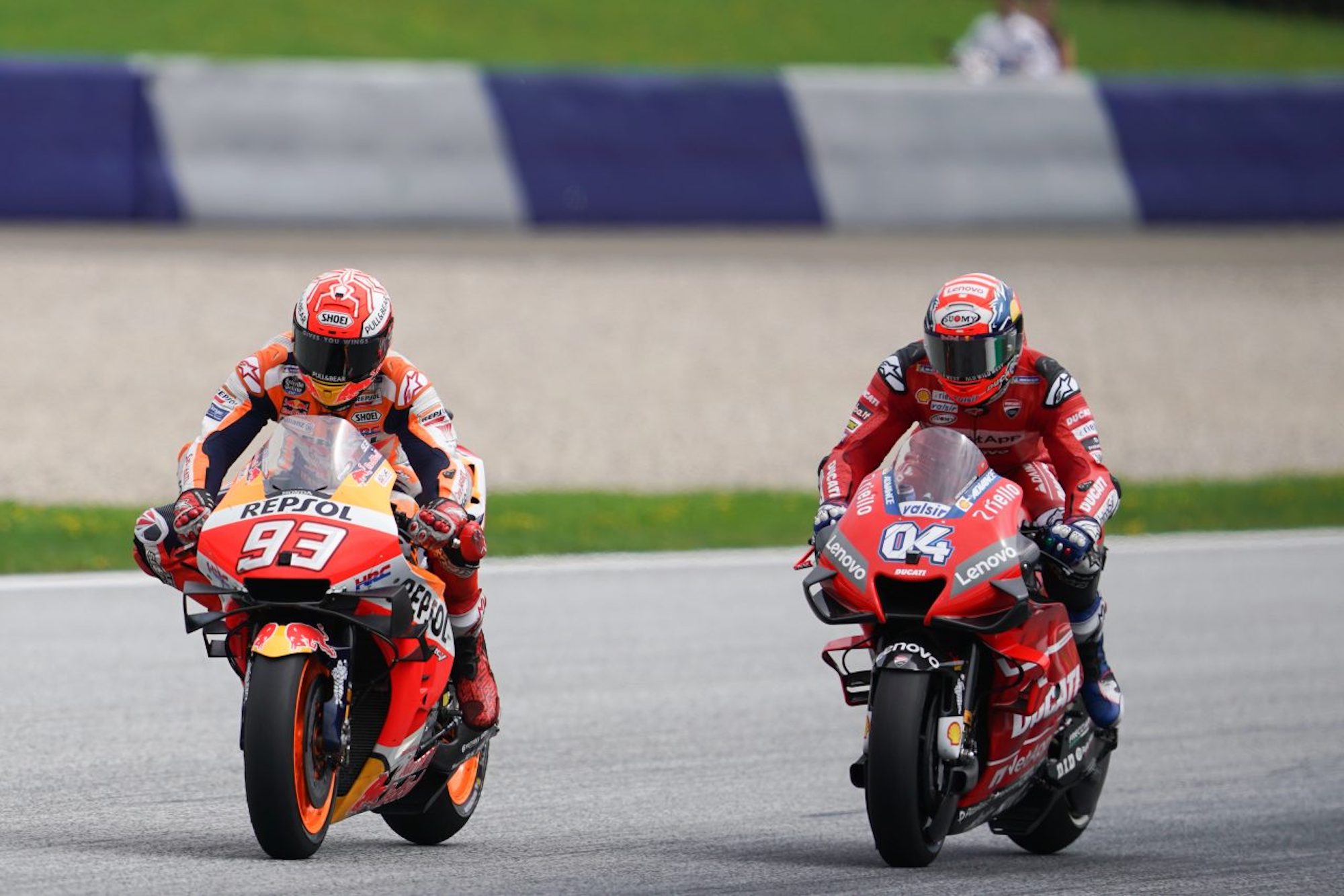 A REPSOL bike (Marc Marquez) with a Ducati Lenovo bike on his heels. Media sourced from Motor Sports.