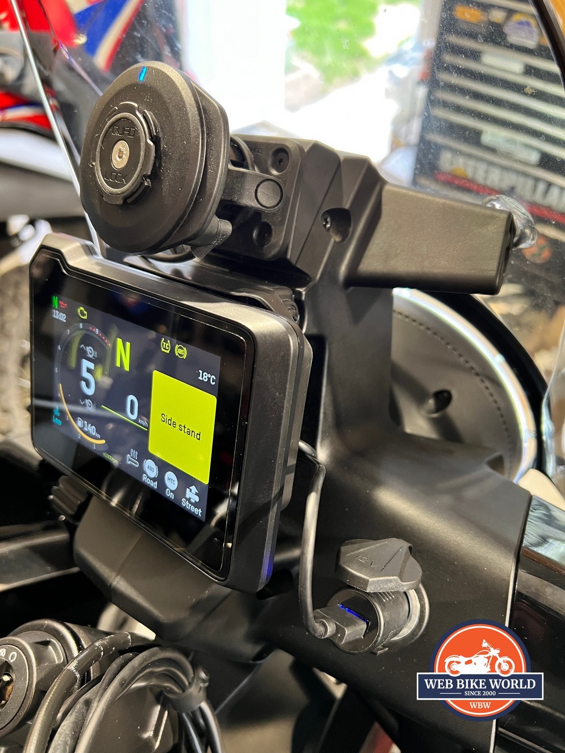 The QuadLock wireless charging head power cord plugged into the Norden’s 12V accessory outlet.