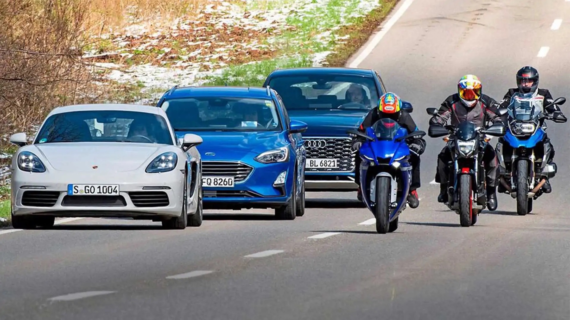 Several cars next to a handful of motorcyclists. Media sourced from RideApart.