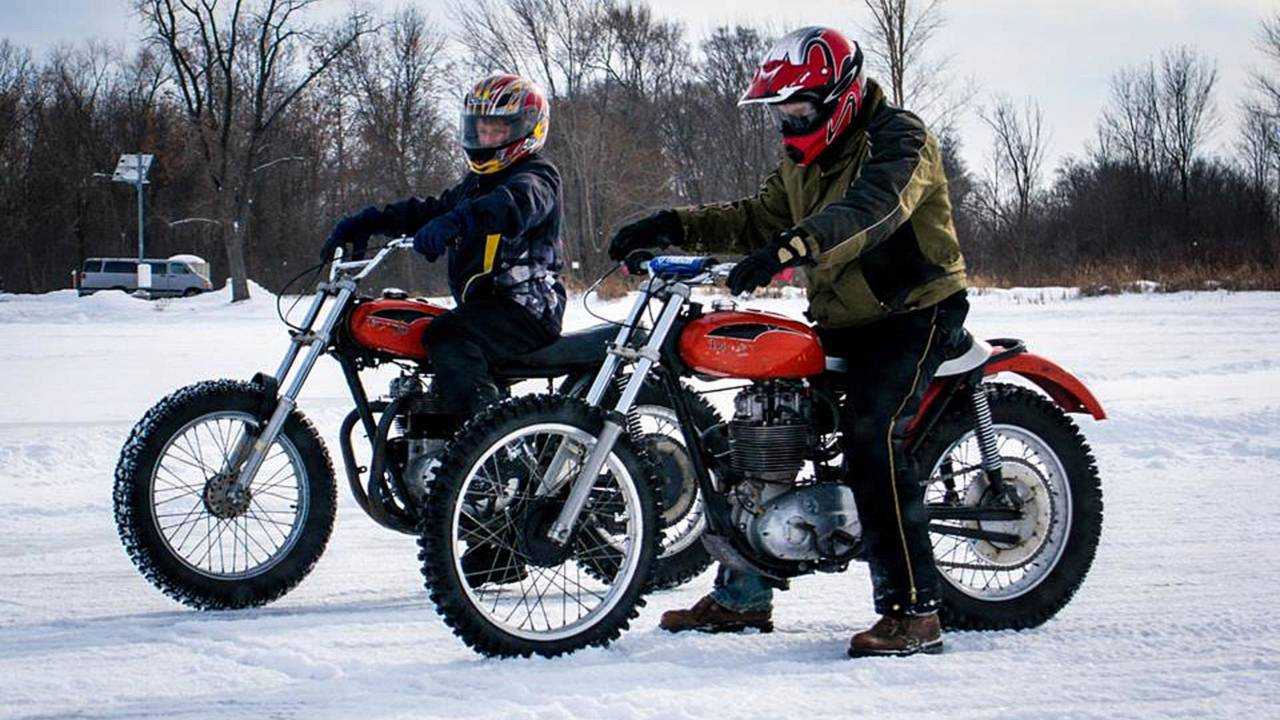 two amature ice speedway motorcycles sit on the ice ready to ride