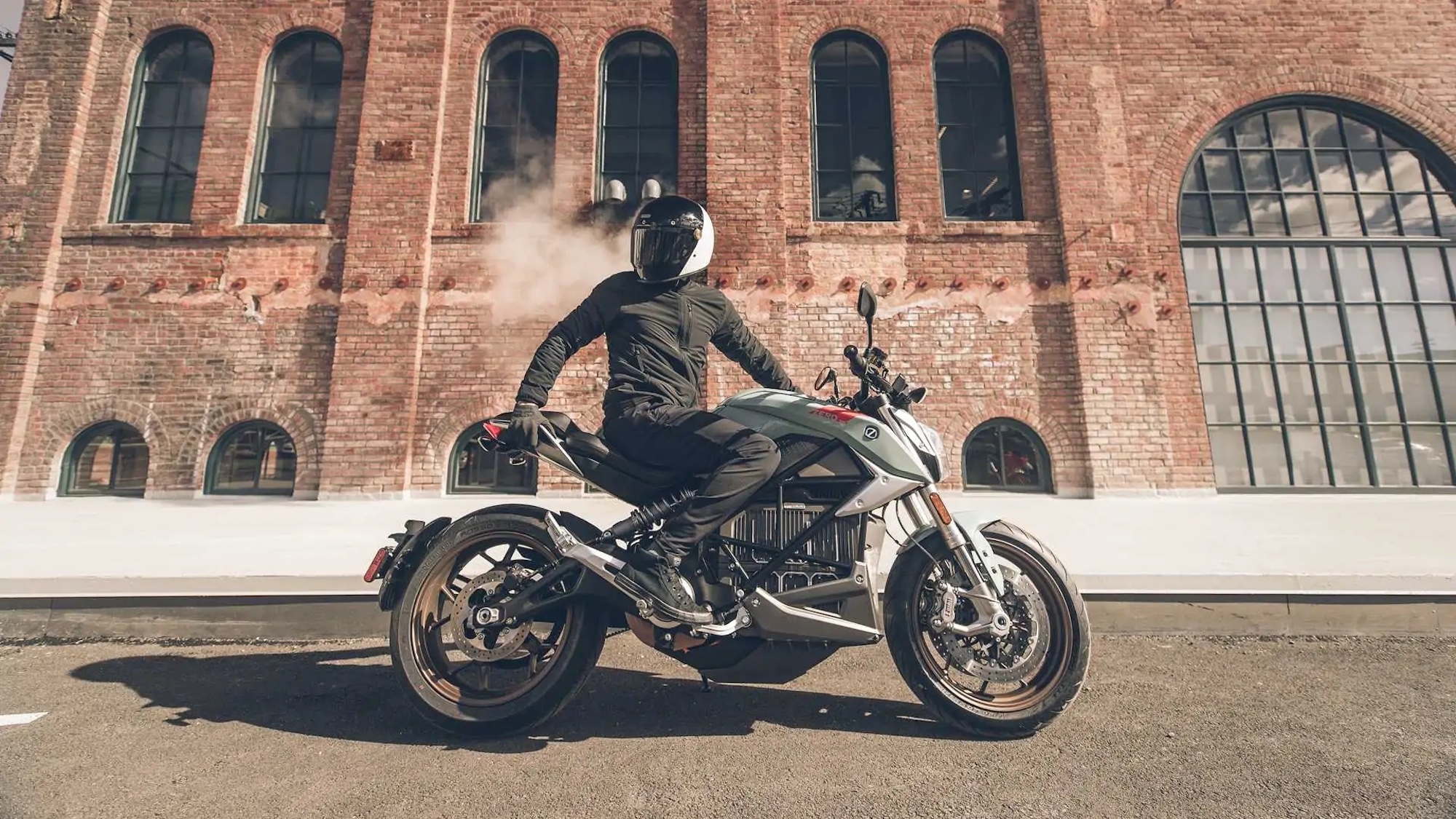 A Zero Motorcycle and rider posing for the crowd. Media sourced from RideApart.