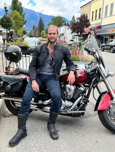 Author leaning on motorcycle saddle while wearing Scorpion EXO Covert Ultra Jeans