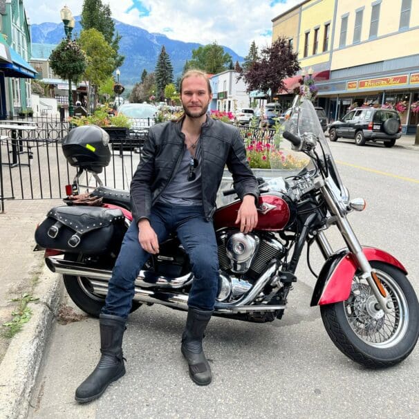 Author leaning on motorcycle saddle while wearing Scorpion EXO Covert Ultra Jeans