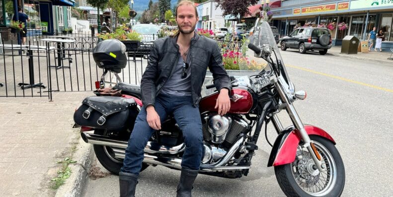 Author leaning on motorcycle saddle while wearing Scorpion EXO Covert Ultra Jeans