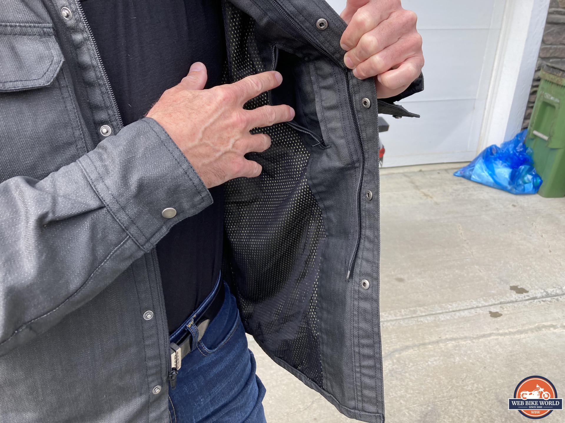 Author reaching for internal pocket in Scorpion EXO Covert Waxed Riding Shirt
