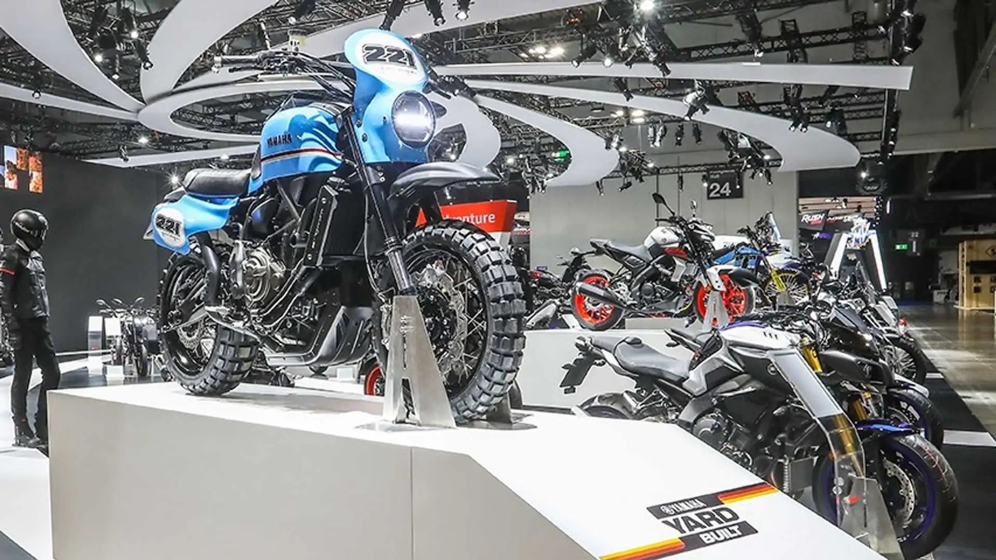 A blue motorcycle on a platform at EICMA. Media sourced from RideApart. 