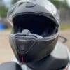 Nexx X.Vilitur Carbon Zero Pro resting on motorcycle seat with visor open