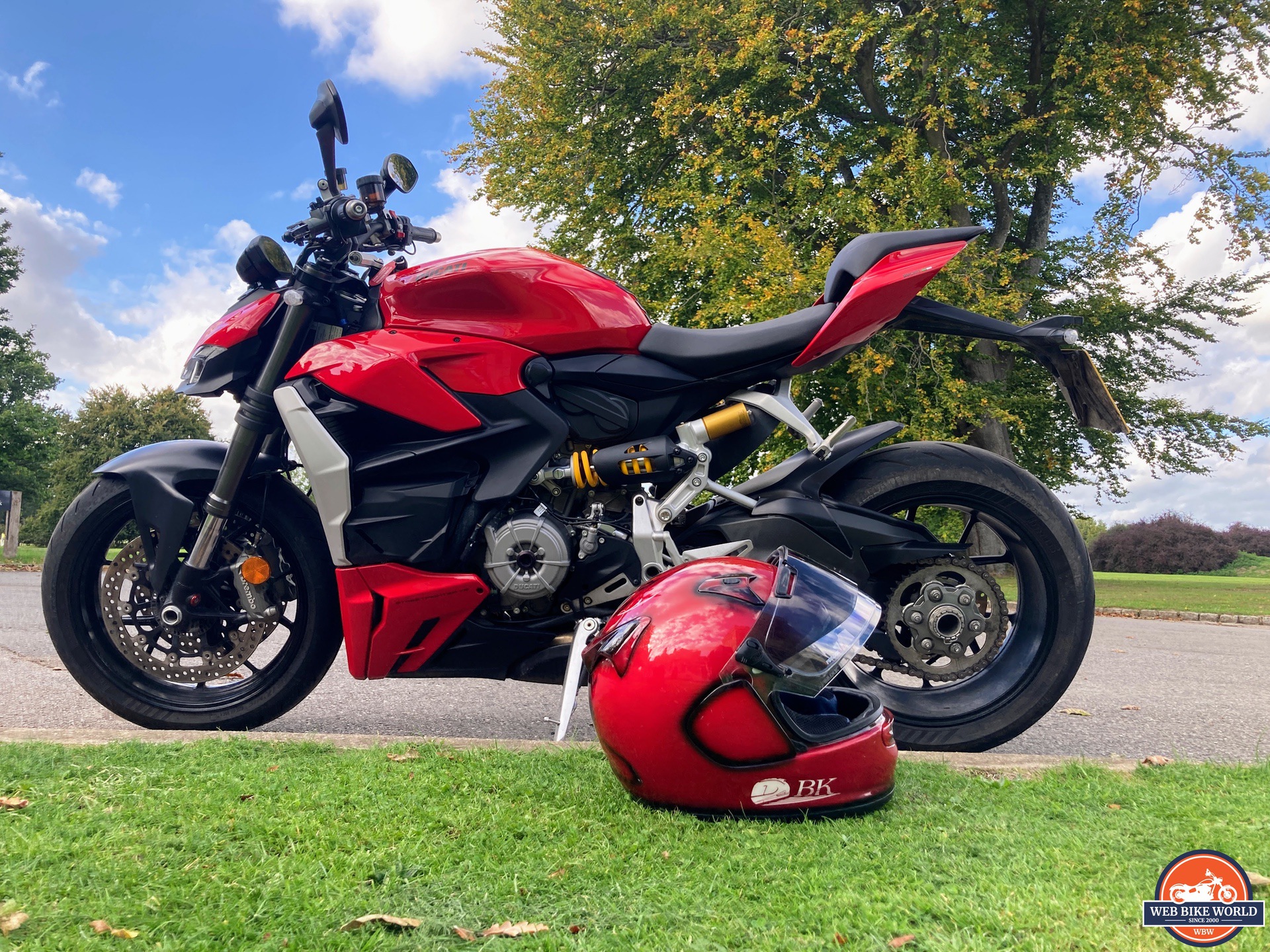 Red helmet lying on grass next to 2022 Ducati V2 Streetfighter