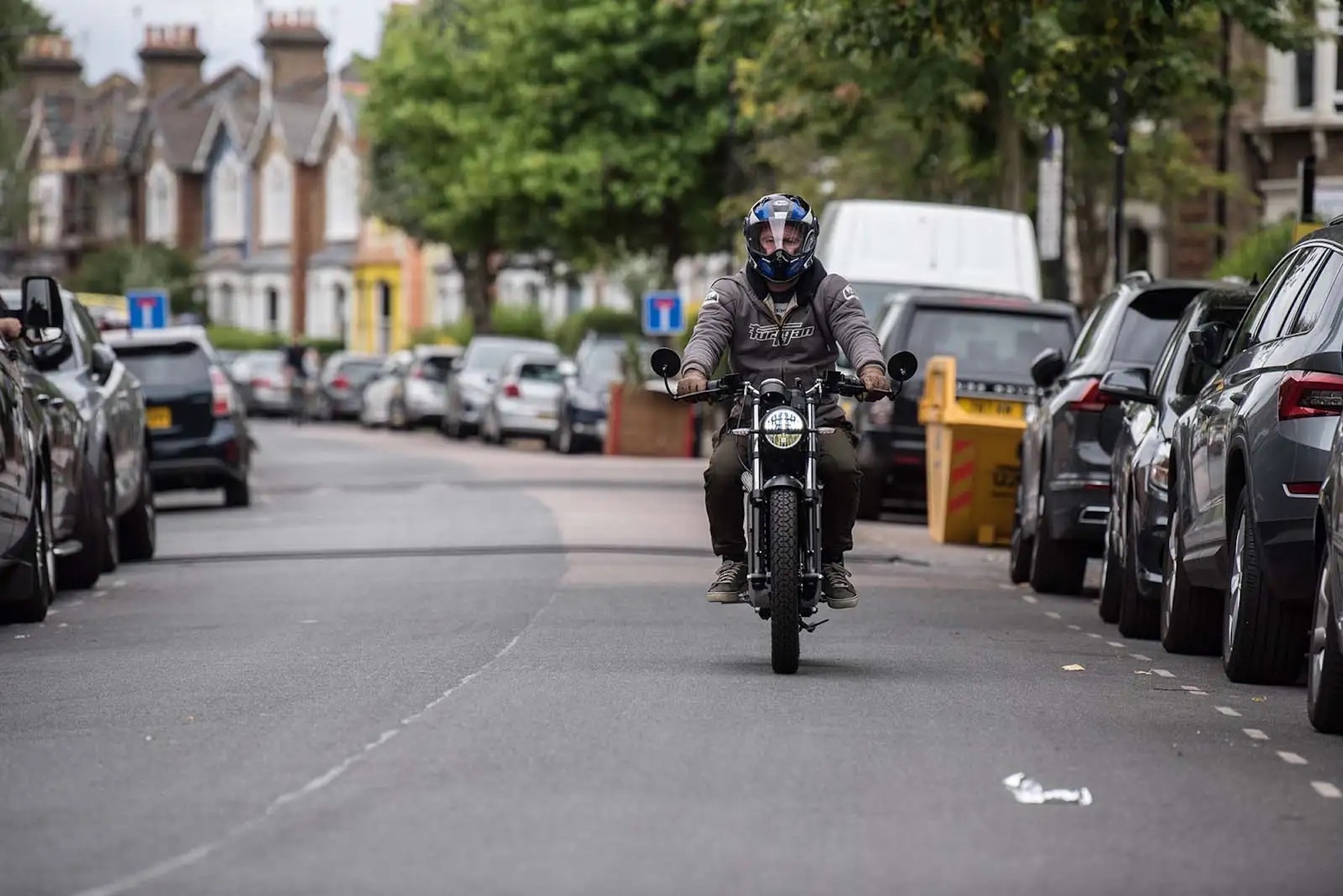 a motorcyclist riding down a lane. Media sourced from Autocrat.