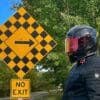 Author wearing Icon Airframe Pro Carbon Helmet and standing next to road sign