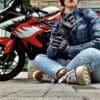 Author sitting cross-legged in front of motorcycle while wearing the Racer USA Women's Pitlane Gloves