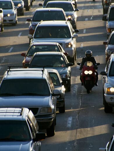 An image of a motorcyclist filtering through traffic.
