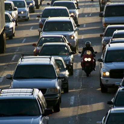 An image of a motorcyclist filtering through traffic.