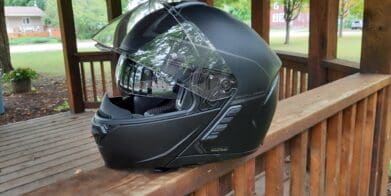 Sena Impulse Modular Helmet sitting on wooden railing