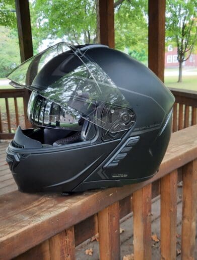 Sena Impulse Modular Helmet sitting on wooden railing