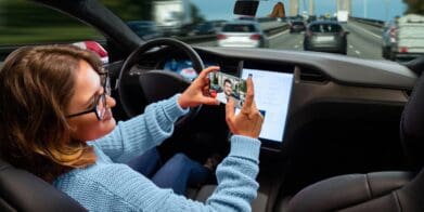 A self-driving owner looking at their screen. Media sourced from The Guardian.