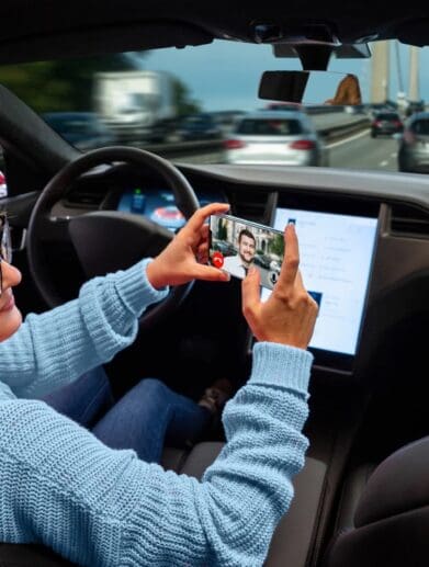 A self-driving owner looking at their screen. Media sourced from The Guardian.