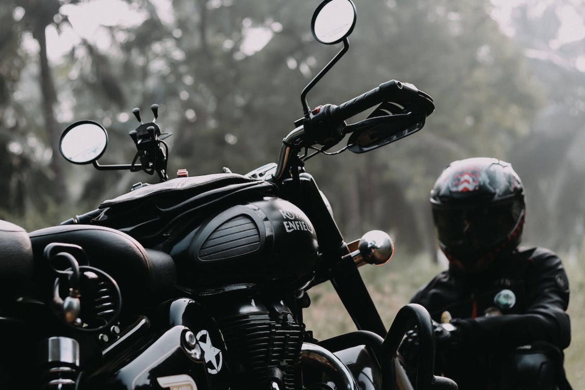 A Royal Enfield with rider sitting nearby. Media sourced from Deutschmann Law.