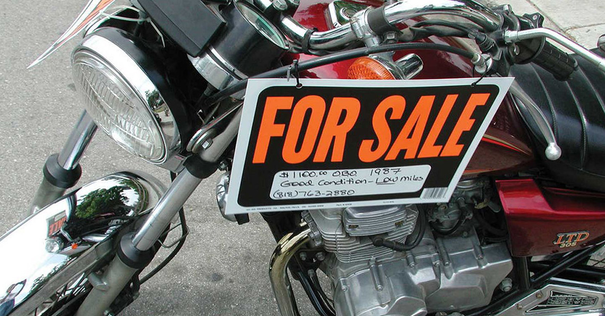 Vintage motorcycle with a "for sale" sign
