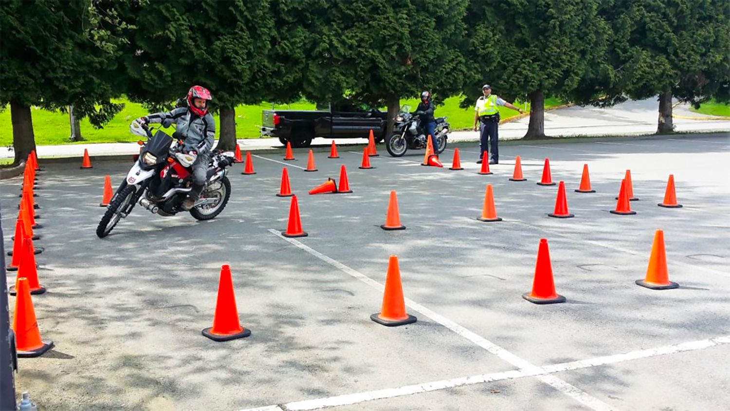 a motorcyclists undergoes training in a car park area a motorcyclists undergoes training in a car park area