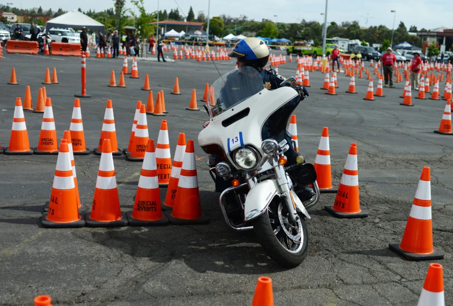 A motorcycle policeman competes in a gymkhana event in a car park