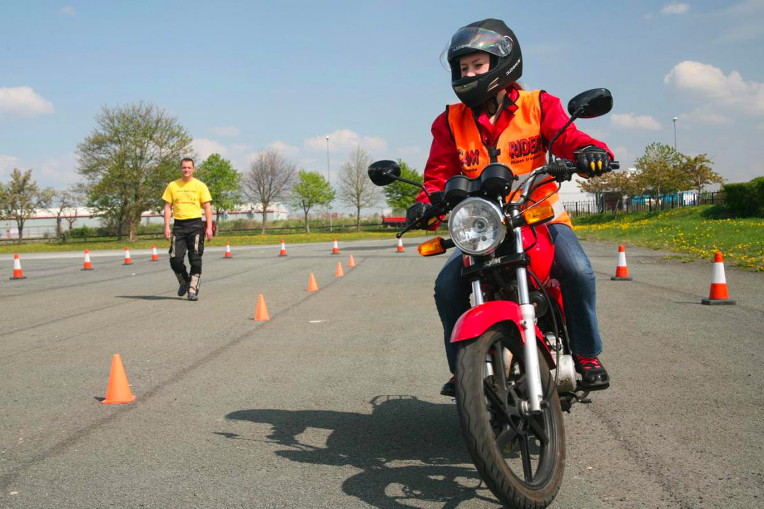 a motorcyclists undergoes training in a car park area a motorcyclists undergoes training in a car park area