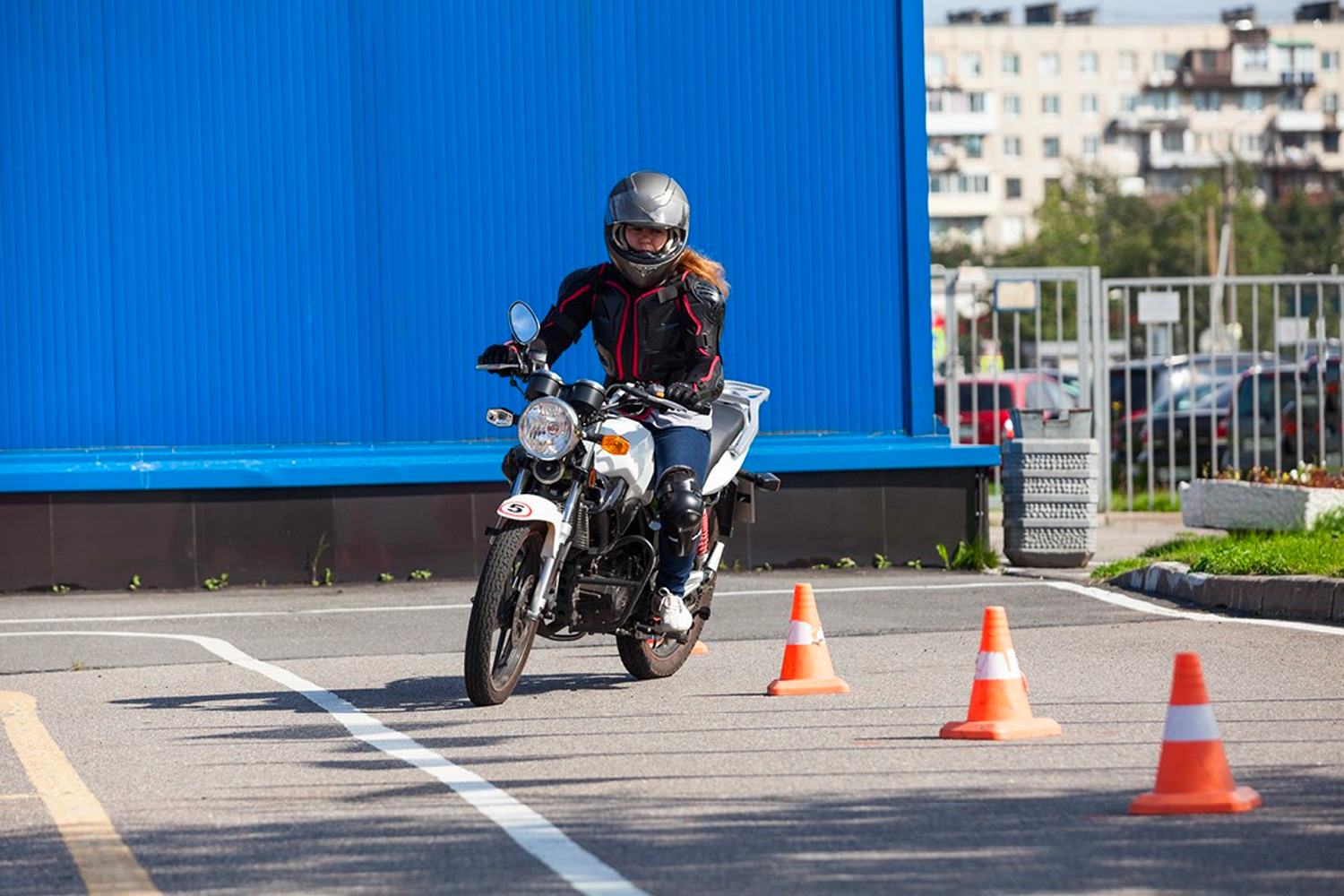 a motorcyclists undergoes training in a car park area a motorcyclists undergoes training in a car park area