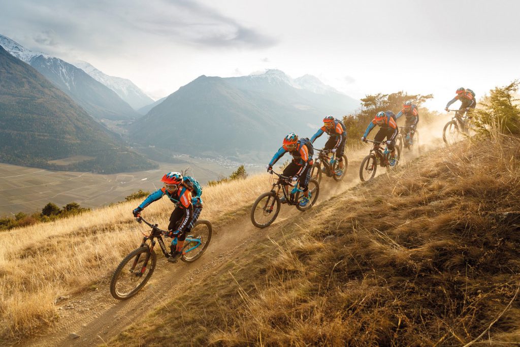 Group of off-road trail riders on Accell Group eBikes riding down mountain