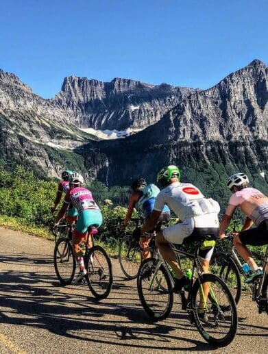 Group of road cyclists riding near mountains and wilderness