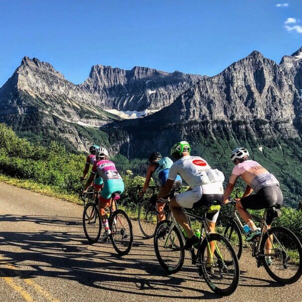 Group of road cyclists riding near mountains and wilderness