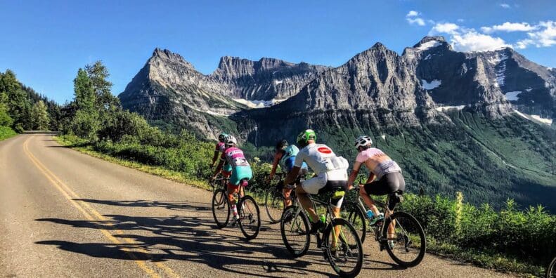 Group of road cyclists riding near mountains and wilderness
