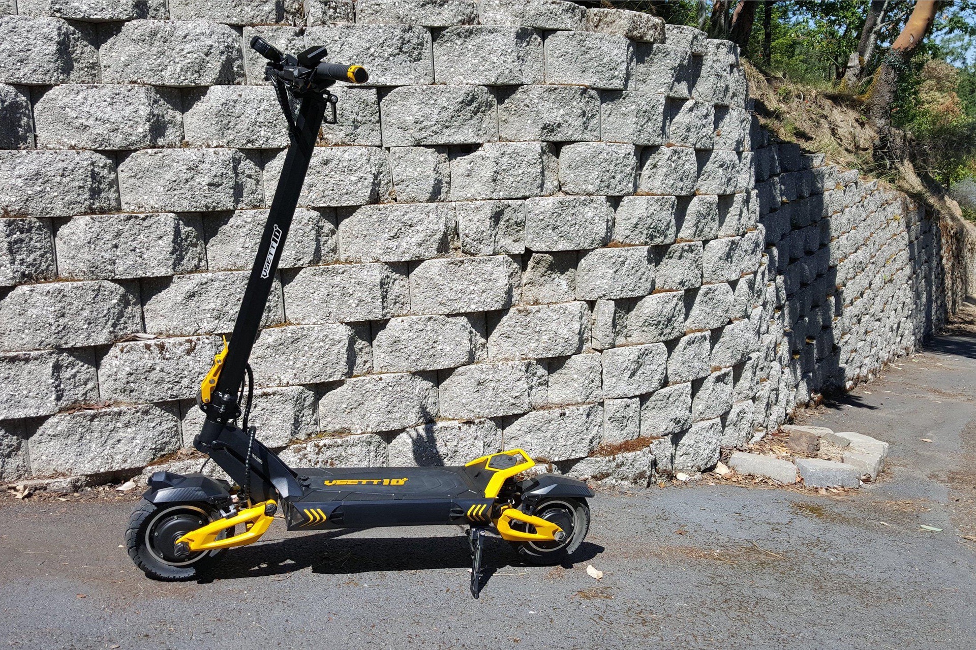 VSETT 10+R long range eScooter rests on kickstand near wall and pathway