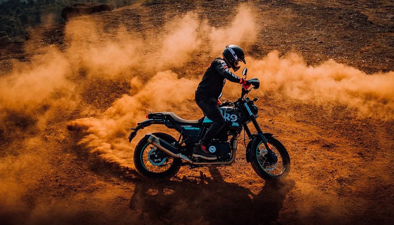 A 2022 Royal Enfield Scram 411 motorcycle kicks up some desert dirt at dusk