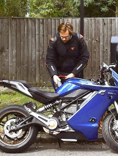 A view of an electric motorcycle plugged in for a charge. Media sourced from Autocar.